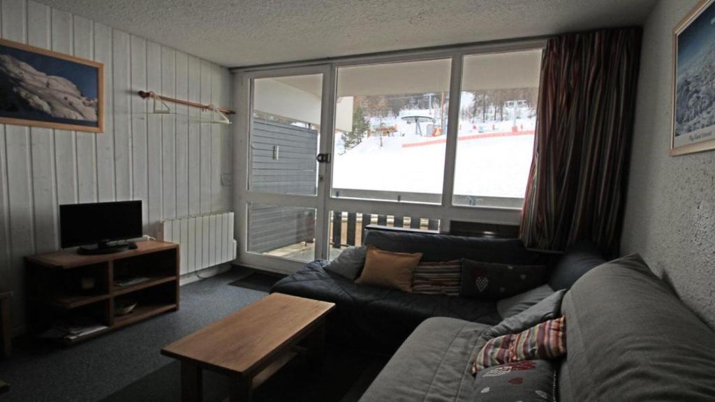 un salon avec un canapé et une télévision dans l'établissement Résidence Cortina 3 - C3302 - APPT T2 CABINE - BALCON - 6 PERSONNES MAE-8564, à Les Prés