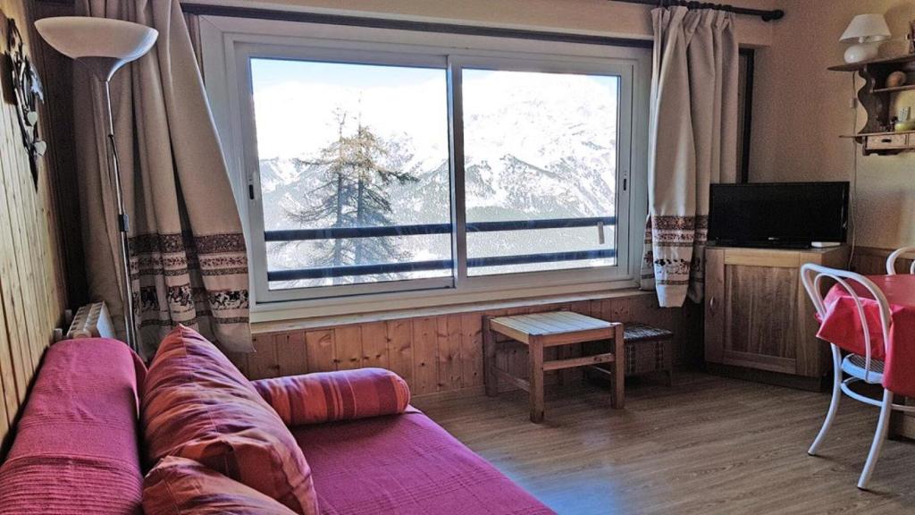 un salon avec un canapé et une grande fenêtre dans l'établissement Résidence Pendine 2 - P2303 - Grand studio - 4 personnes - Centre de station MAE-8974, à Les Prés