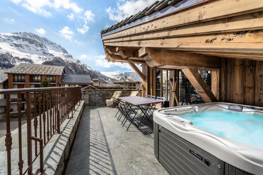 a hot tub on the balcony of a house with mountains at Résidence Grizzly - Pièces 544 in Val-d'Isère