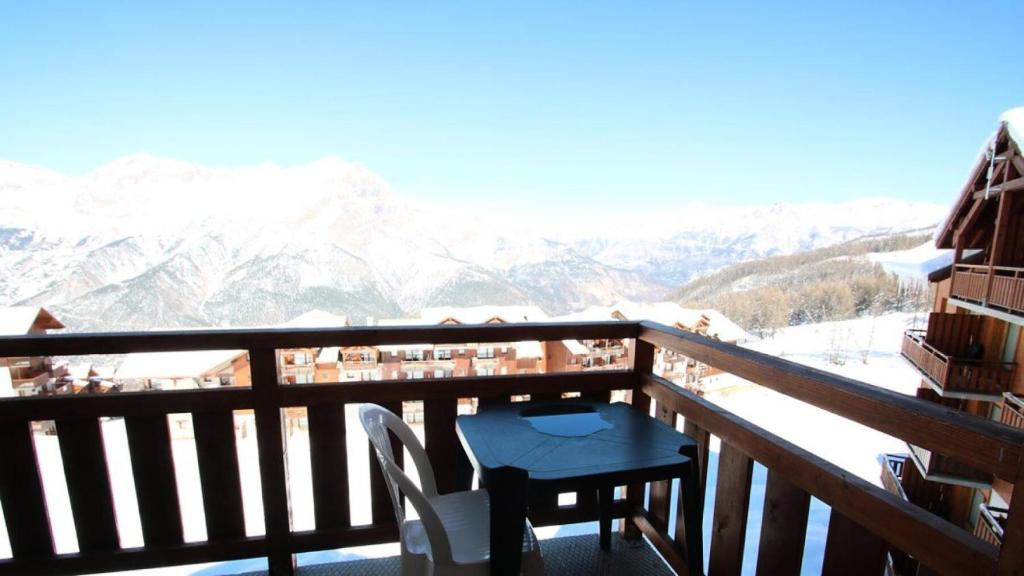 un balcon avec une table et une vue sur les montagnes dans l'établissement Résidence Parc Aux Etoiles - C402PAE - APPARTEMENT 2 CHAMBRES AVEC BALCON MAE-8754, à Narreyroux