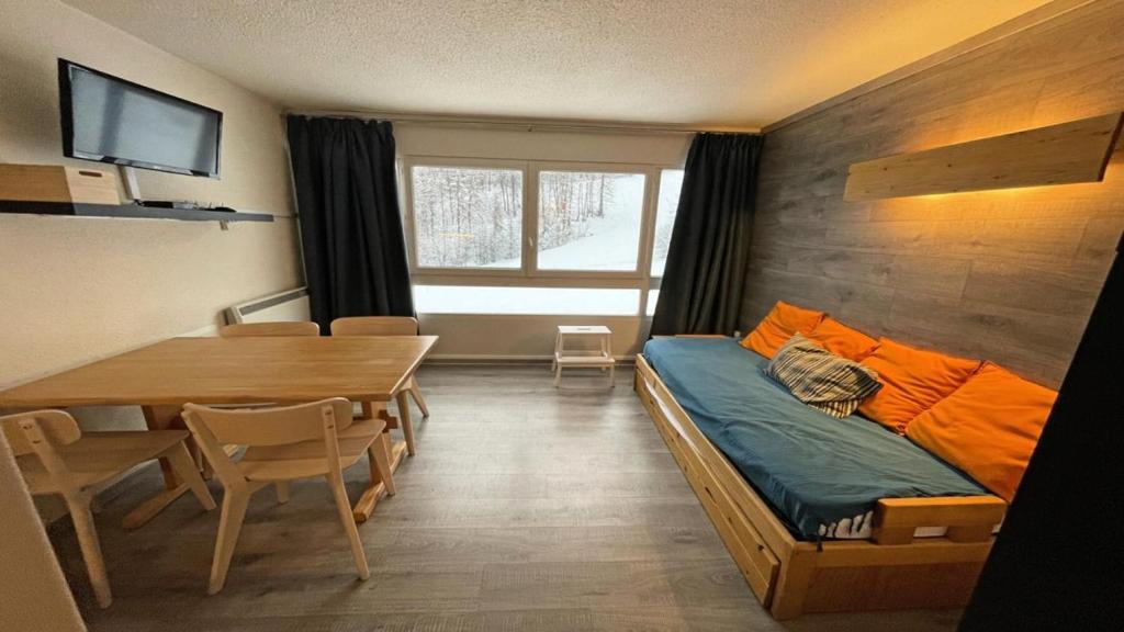 Habitación con cama y mesa de comedor. en Résidence Valgardena - Appartements pour 4 Personnes 864 en Les Prés