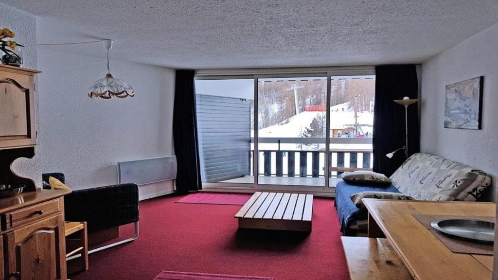 a living room with a couch and a large window at Résidence Cortina 2 - Appartements pour 6 Personnes 884 in Les Prés