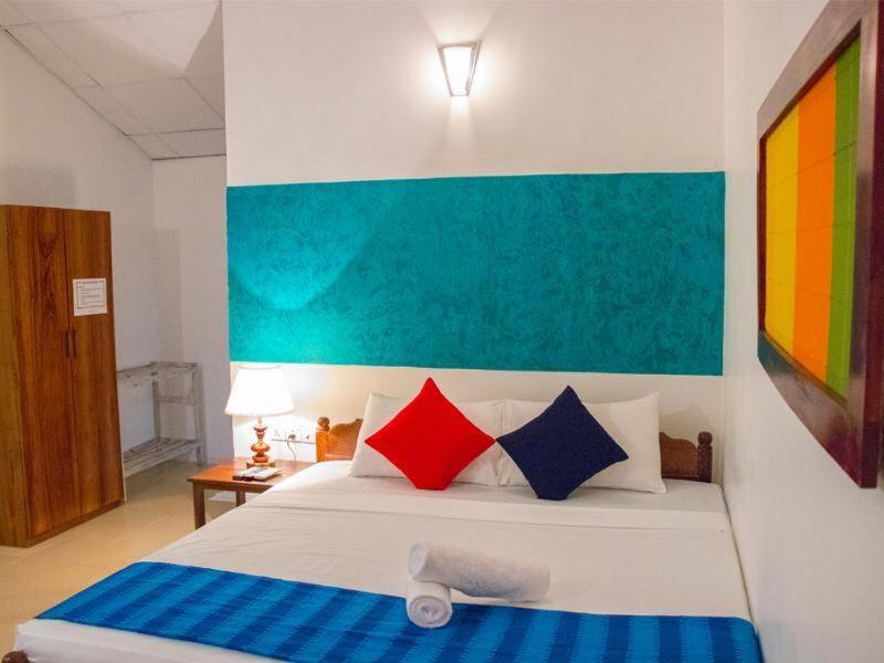 um quarto com uma cama grande e almofadas coloridas em Star Dambulla em Dambulla