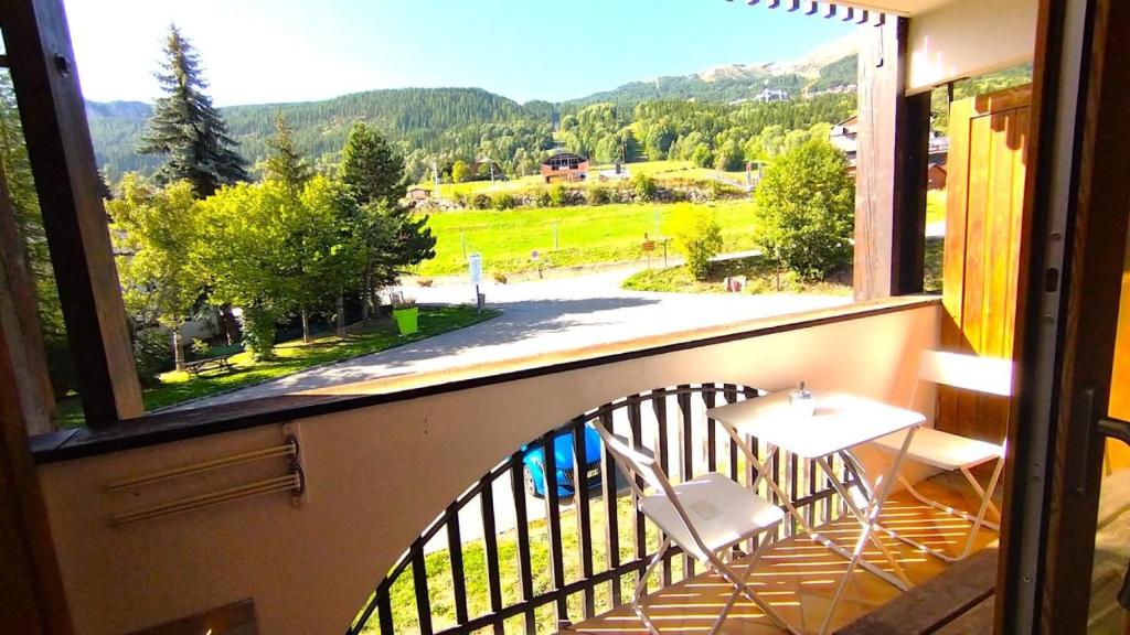 balcone con tavolo e sedie affacciato su una finestra di Résidence Saint Roch - Agréable Studio 4 Personnes à proximité des pistes+Coin cabine MAE-8044 a Puy-Saint-Vincent