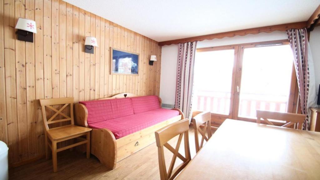 Zimmer mit einem rosa Sofa und einem Tisch in der Unterkunft Résidence Parc Aux Etoiles - Appartements pour 6 Personnes 064 in Narreyroux
