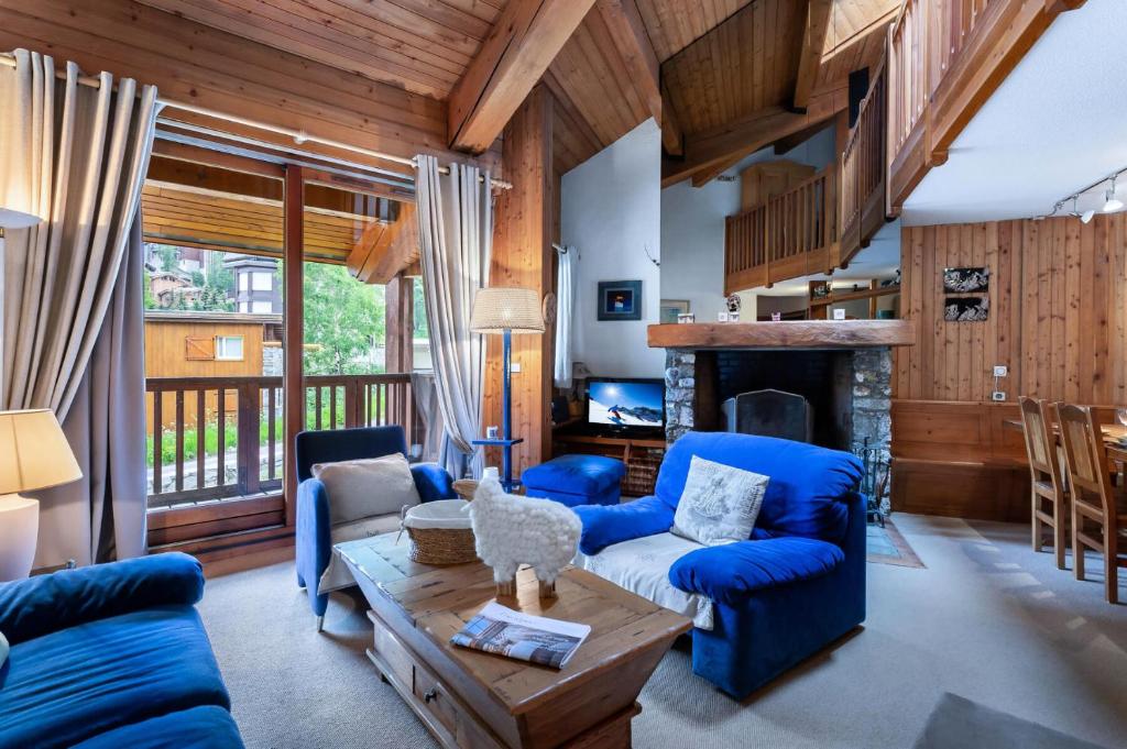 a living room with blue furniture and a fireplace at Residence Calabourdane - 3 Pièces pour 7 Personnes 714 in Val-d'Isère