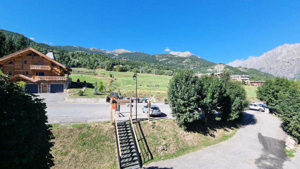 a view of a building with mountains in the background at Le Chalet - Appartements pour 6 Personnes 304 in Puy-Saint-Vincent