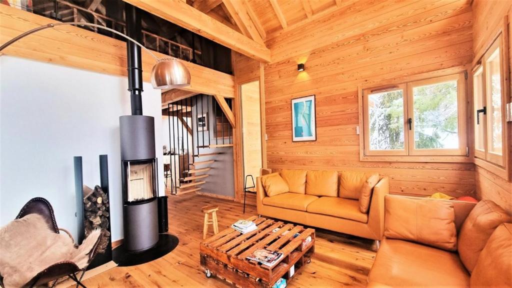 a living room with a couch and a fireplace at Chalet Piganiol-puy-saint-vincent - Chalets 684 in Les Prés