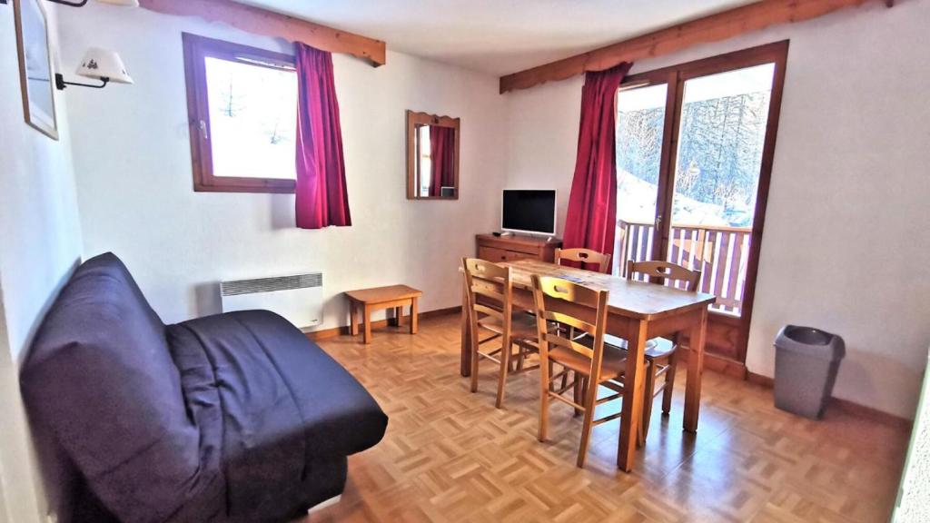 un soggiorno con divano e tavolo da pranzo di Résidence Les Gentianes - Appartements pour 6 Personnes 204 a Narreyroux