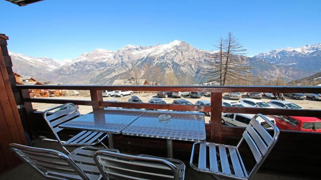 a table and chairs on a balcony with mountains at Résidence Dame Blanche - 2 Pièces pour 6 Personnes 634 in Narreyroux