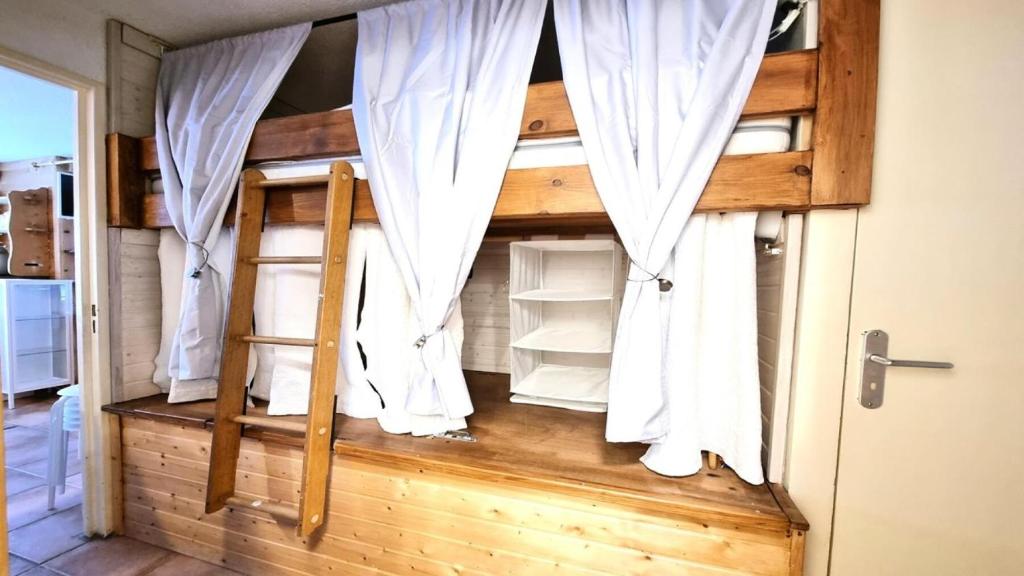 a room with two bunk beds with white curtains at Résidence Valgardena - Appartements pour 4 Personnes 471 in Puy-Saint-Vincent