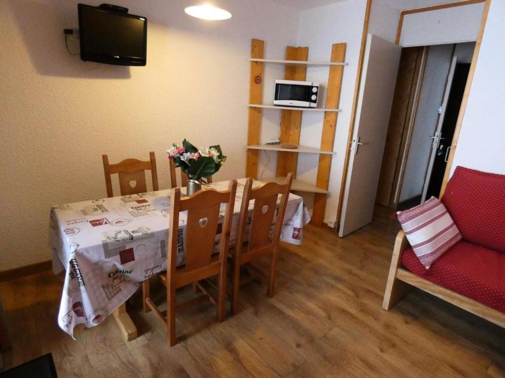 Cette petite chambre comprend une table, des chaises et un canapé. dans l'établissement Résidence Portail - Le Portail 27 - Agréable 2 pièces en bordure de piste MAE-4664, à Valmorel