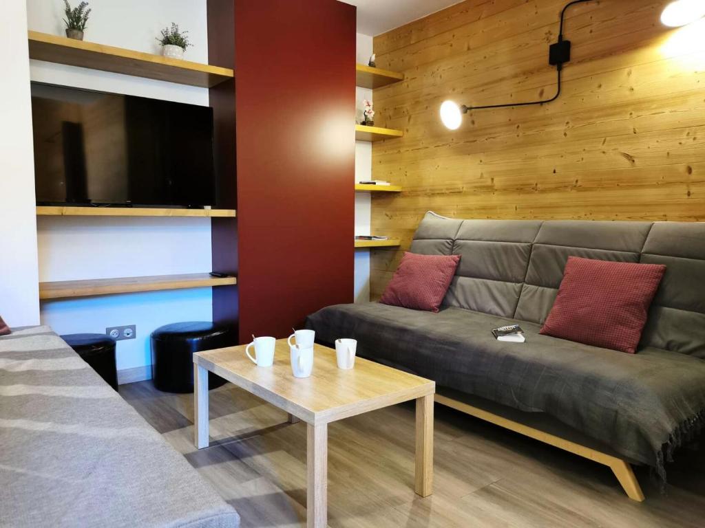 un salon avec un canapé et une table dans l'établissement Résidence Lauziere Dessous - La Lauzière Dessous 50 - Triplex offrant charme et modernité MAE-5134, à Valmorel