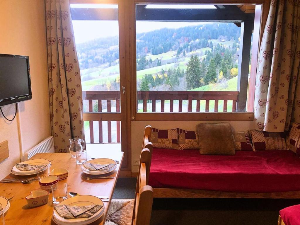 d'une table à manger avec une grande fenêtre offrant une vue. dans l'établissement Résidence Camarine - La Camarine 30 - Agréable 2 pièces, au pied des pistes MAE-5464, à Valmorel