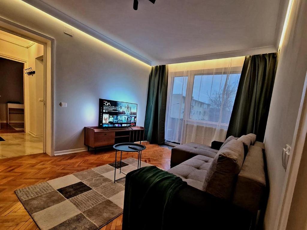 a living room with a couch and a television at Campia Turzii central apartment in Cîmpia Turzii