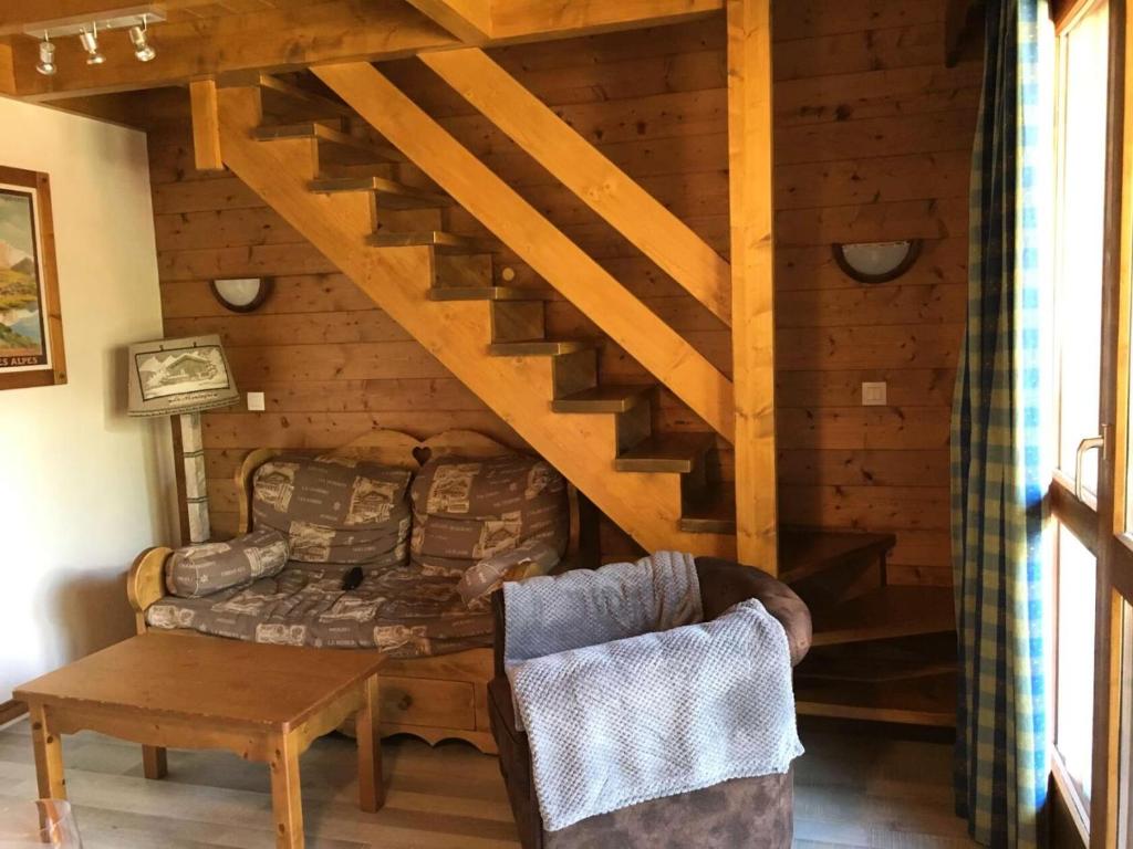 un salon avec un canapé et un escalier dans l'établissement Résidence Athamante - L'Athamante 50- 2 pièces+mezzanine, intérieur cosy, classé 3 étoiles MAE-5514, à Valmorel