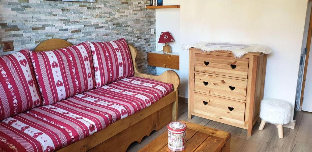 - un salon avec un canapé et une commode en bois dans l'établissement Résidence Pierrer - Le Pierrer 51 - Studio divisible joliment rénové, classé 2 étoiles MAE-4044, à Valmorel