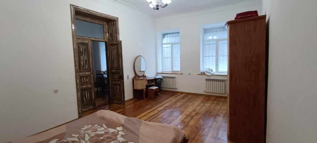 an empty living room with wooden floors and windows at Ganja house in Ganja