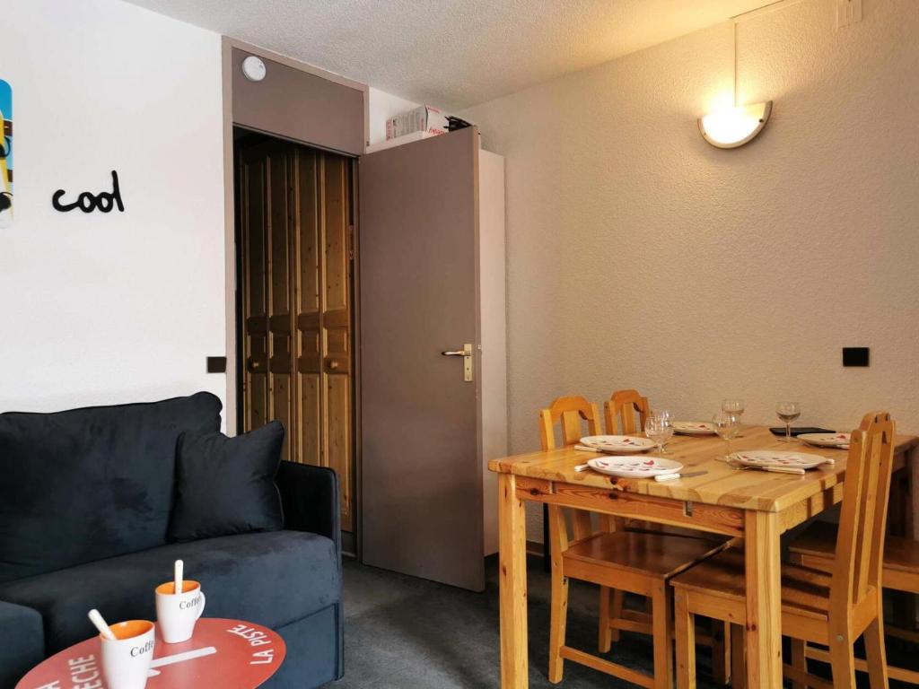 - un salon avec une table en bois et un canapé bleu dans l'établissement Résidence Riondet - Le Riondet 5 - Agréable 2 pièces en rez de neige, vue magnifique MAE-5524, à Valmorel