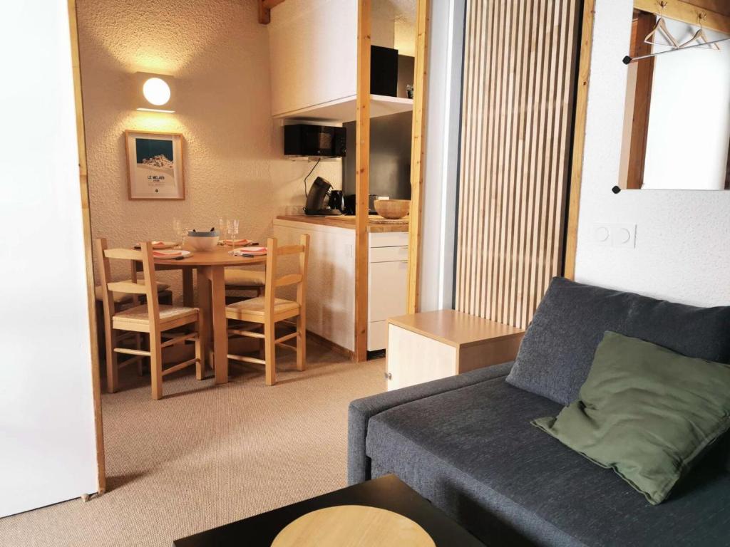 un salon avec un canapé et une cuisine avec une table dans l'établissement Résidence Pierres Plates - Les Pierres Plates 49 - Agréable studio rénové, skis aux pieds MAE-4044, à Valmorel