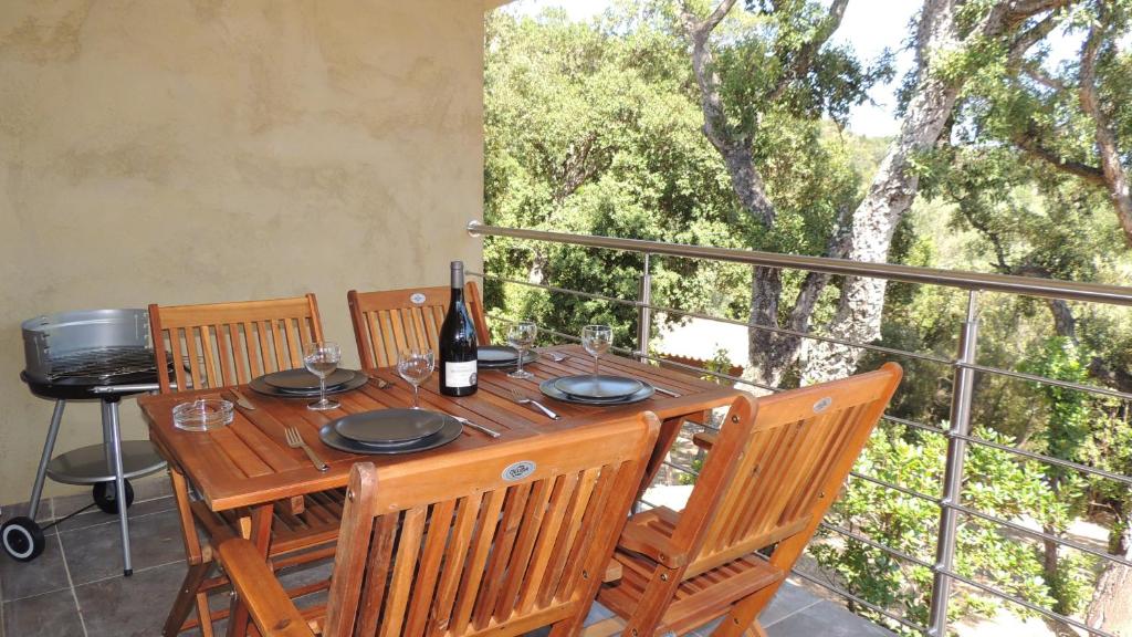 - une table en bois avec une bouteille de vin sur le balcon dans l'établissement Belle mini villa vue montagne au coeur du village de Conca, à Conca
