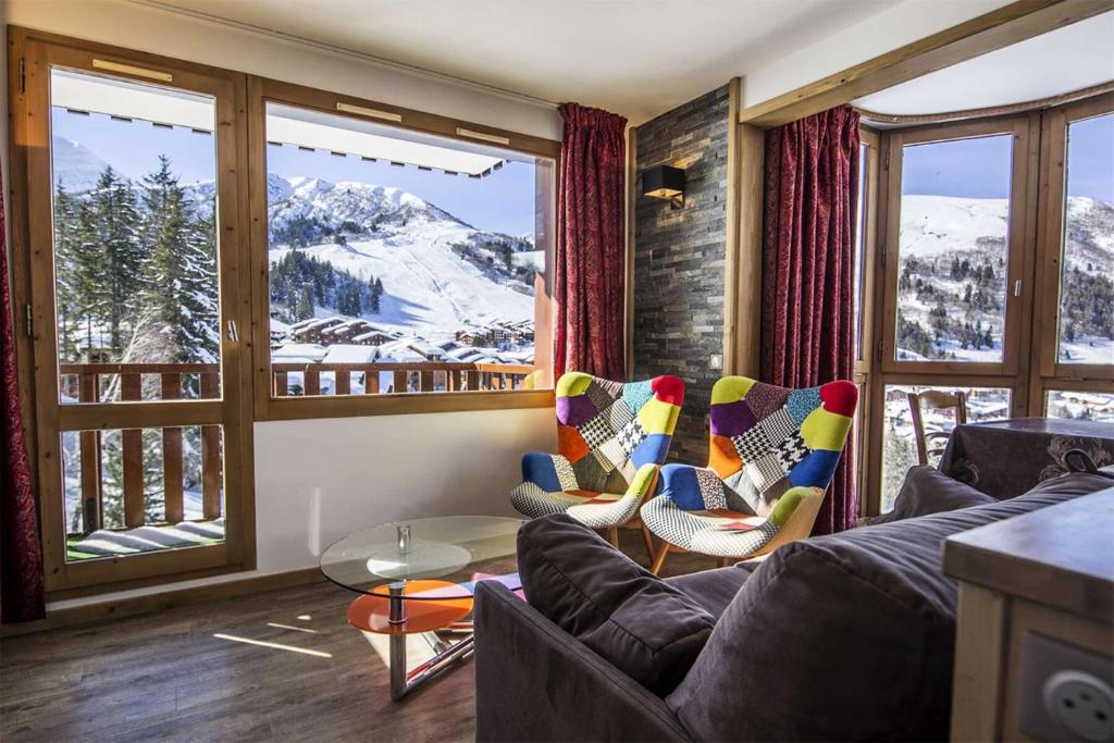 - un salon avec un canapé et des chaises devant une fenêtre dans l'établissement Résidence Cheval Blanc - Le Cheval Blanc C3 - Splendide appartement offrant une vue magnifique MAE-6334, à Valmorel