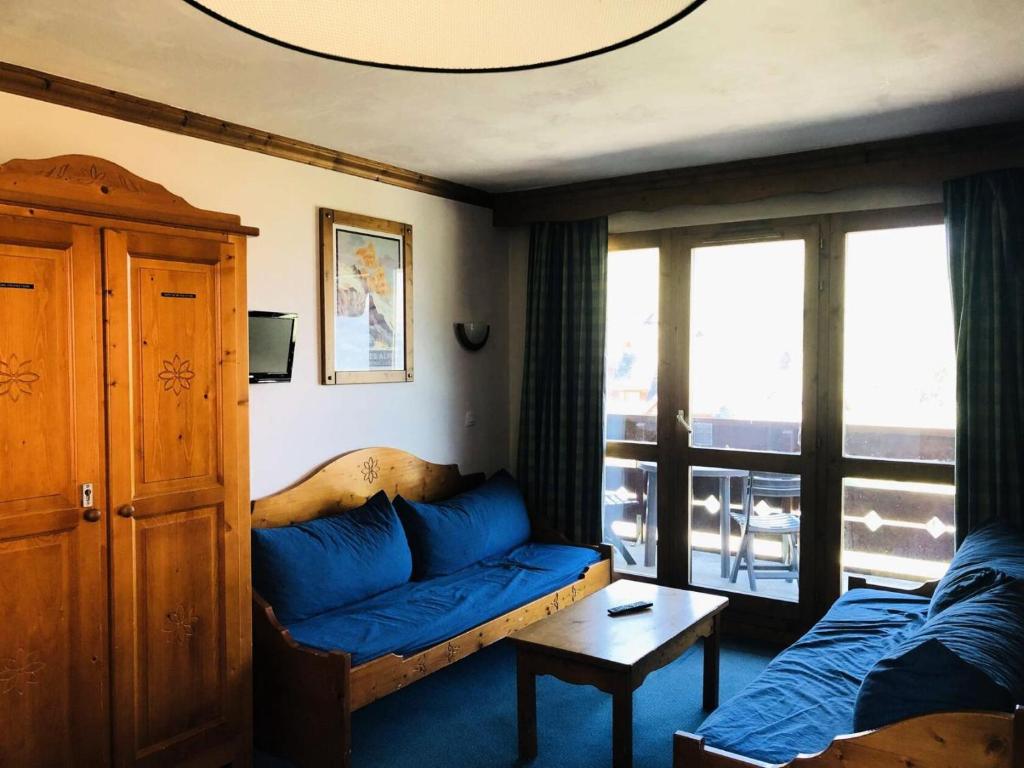 un salon avec un canapé bleu et une fenêtre dans l'établissement Résidence Athamante - L'Athamante 6 - Proche des pistes, de la piste de luge et des commerces MAE-5574, à Valmorel