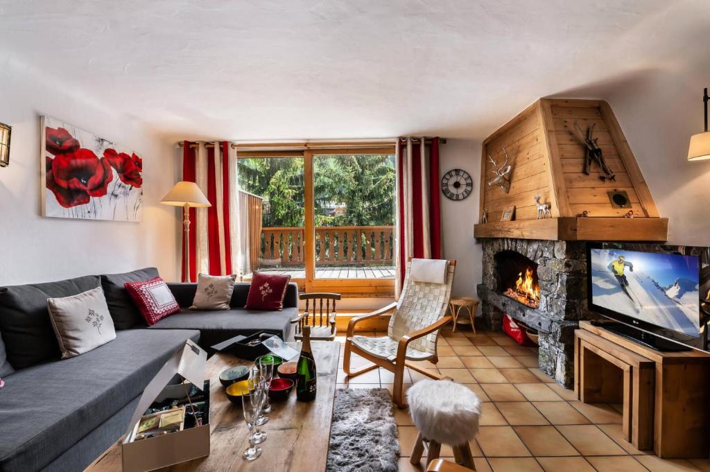 a living room with a couch and a fireplace at Résidence Roc Mugnier - Chalets pour 8 Personnes 504 in Courchevel