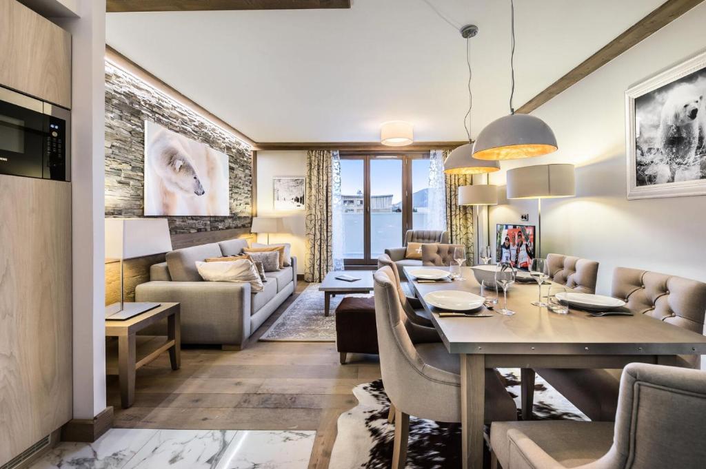 a dining room and living room with a table and chairs at Résidence Carre Blanc - 3 Pièces pour 4 Personnes 504 in Courchevel
