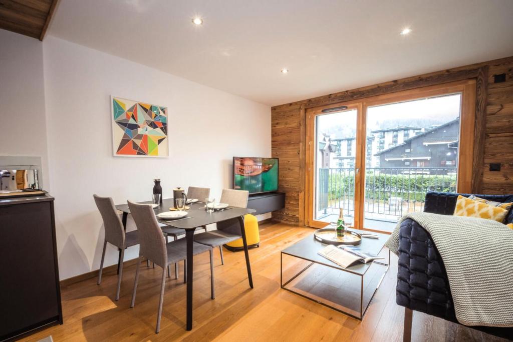 een woonkamer met een tafel en stoelen en een eetkamer bij Résidence Androsace Du Lyret - 2 Pièces pour 2 Personnes 564 in Chamonix-Mont-Blanc