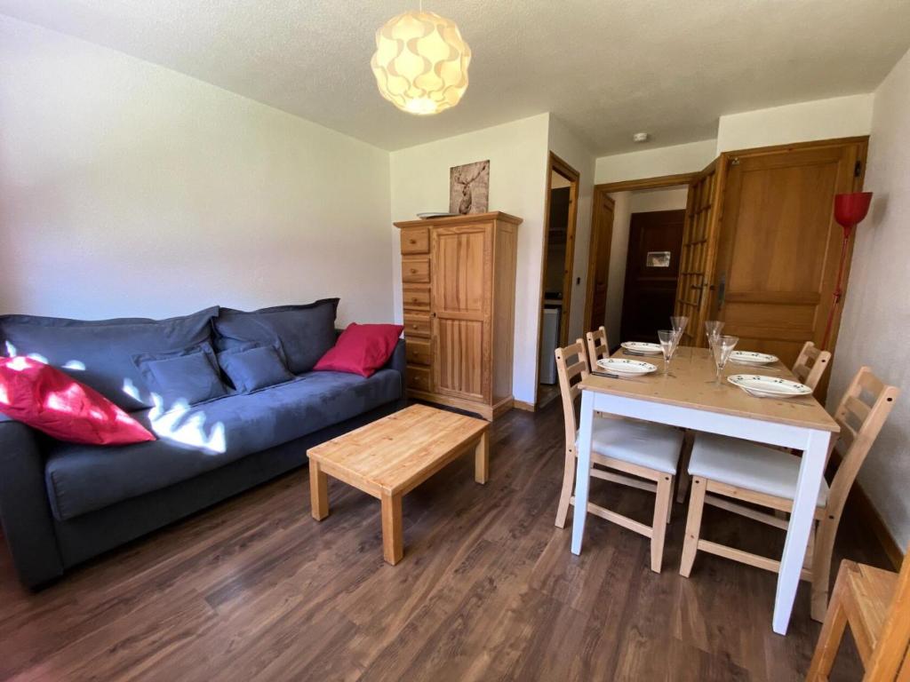 ein Wohnzimmer mit einem blauen Sofa und einem Tisch in der Unterkunft Résidence Clos Du Savoy - Studio pour 4 Personnes 964 in Chamonix-Mont-Blanc