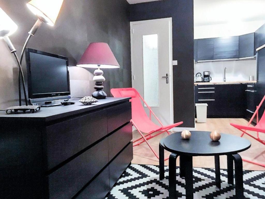 uma sala de estar com uma televisão, uma mesa e uma cozinha em Résidence Cimes - 2 Pièces pour 6 Personnes 324 em Vénosc