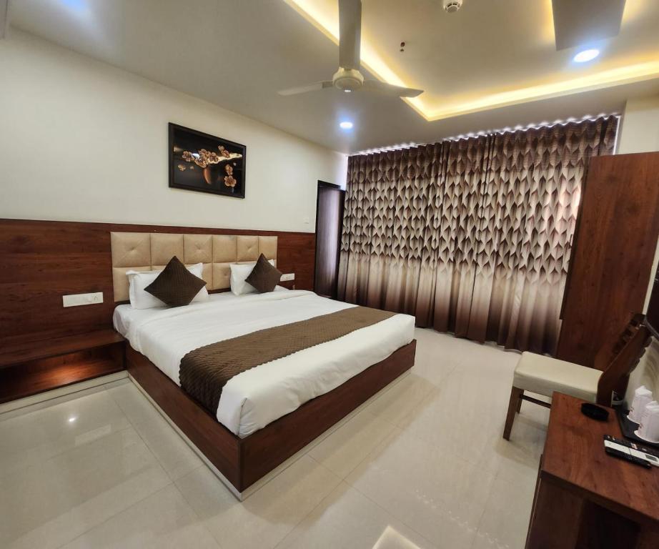 a bedroom with a large bed and a desk at HOTEL 4ReN in Bhavnagar