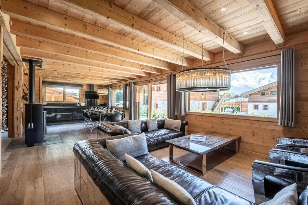 ein Wohnzimmer mit einem Ledersofa und einem Tisch in der Unterkunft Résidence Marius - Chalets pour 10 Personnes 934 in Chamonix-Mont-Blanc