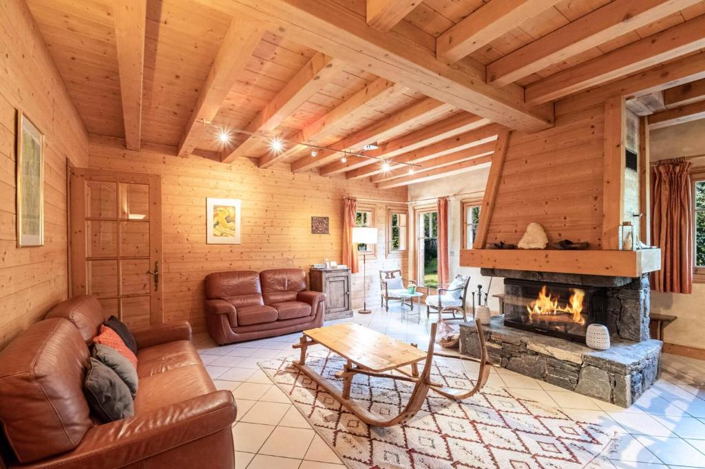 sala de estar con sofá y chimenea en Résidence Perseverance - Chalets pour 12 Personnes 054 en Chamonix-Mont-Blanc