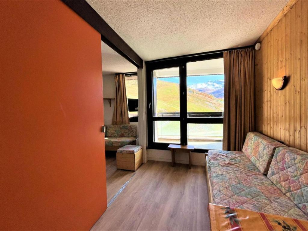un salon avec un canapé et une grande fenêtre dans l'établissement Résidence Genepi - Studio 4 personnes avec vue sur la montagne MAE-4954, aux Menuires