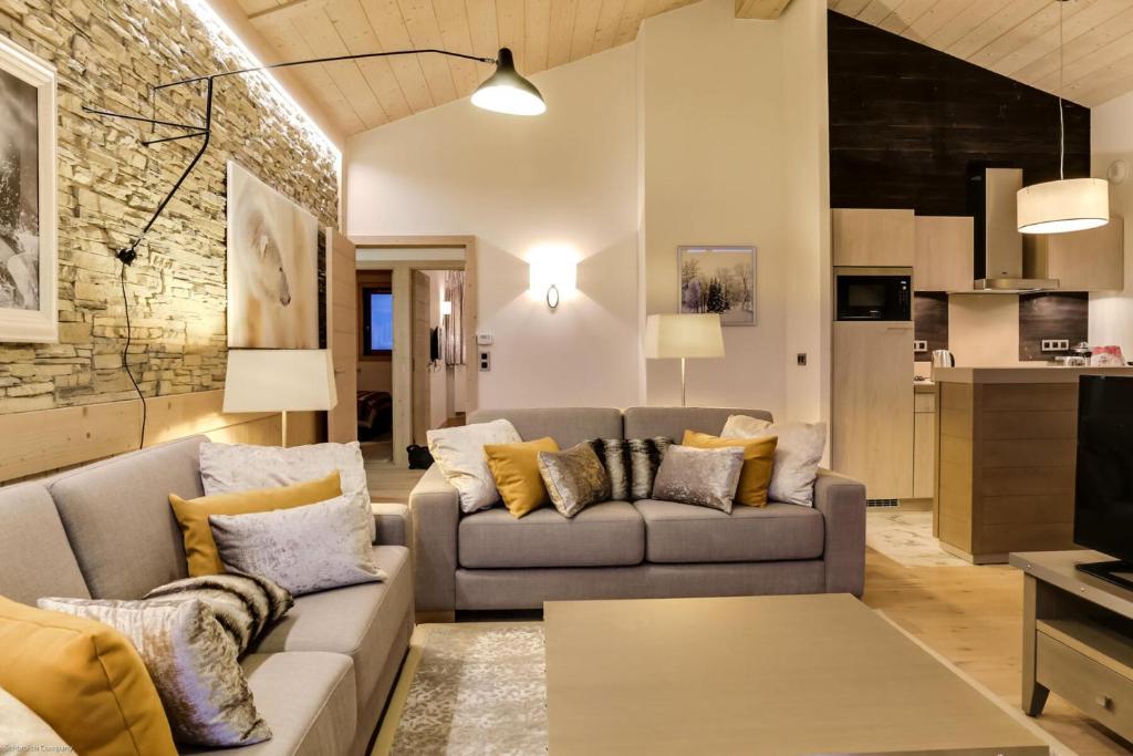 ein Wohnzimmer mit einem Sofa und einem Tisch in der Unterkunft Résidence Carre Blanc - 5 Pièces pour 8 Personnes 264 in Courchevel