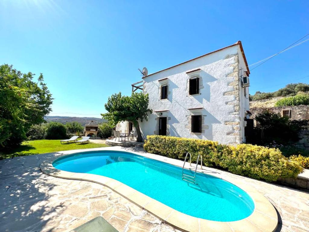 a villa with a swimming pool in front of a building at Villa Ovgoro, Provarma, pool, seaview balcony in Próvarma