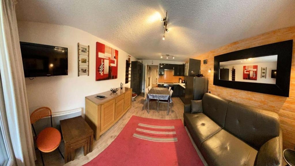 a living room with a couch and a television and a kitchen at Résidence Cesier - 2 Pièces pour 4 Personnes 444 in Risoul