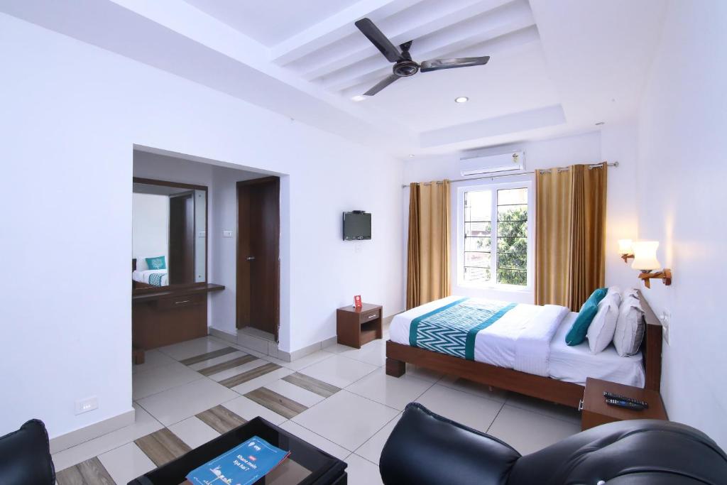 a bedroom with a bed and a ceiling fan at OYO Hotel Pearl View Residency in Ambalavayal