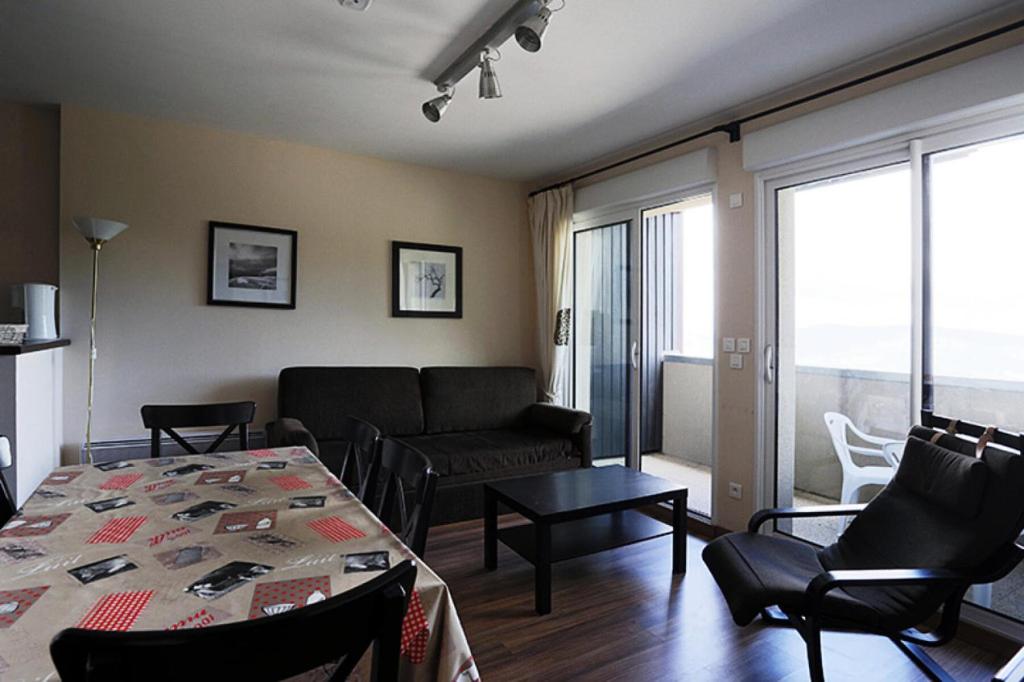 een woonkamer met een bank en een tafel en stoelen bij Résidence Serias - 3 Pièces pour 6 Personnes 484 in Germ
