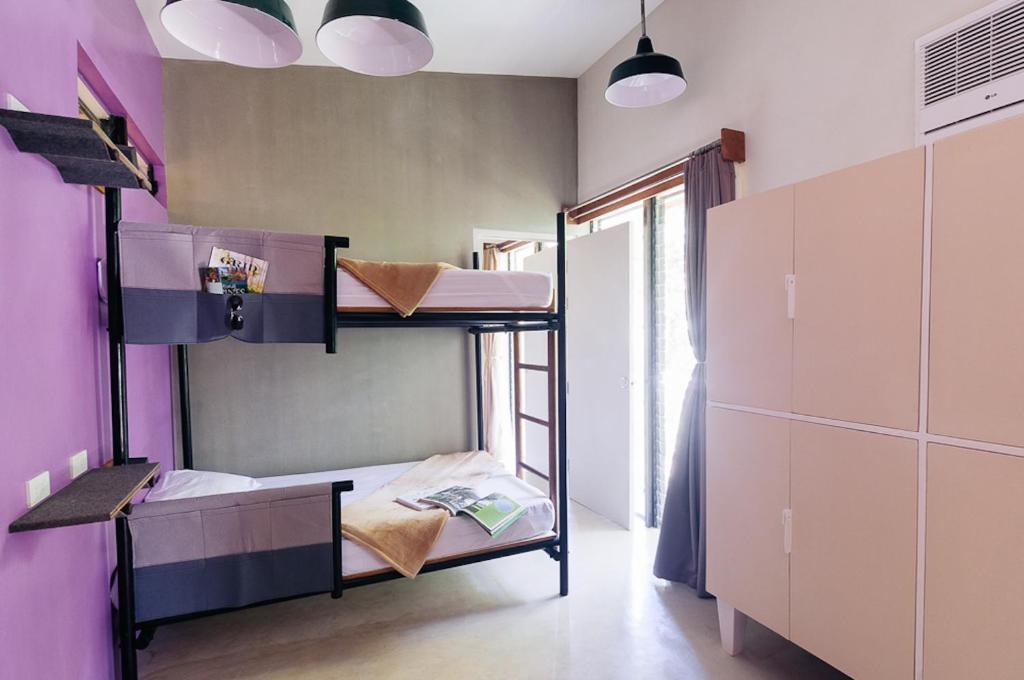 a room with two bunk beds and a window at Spin Designer Hostel - El Nido in El Nido