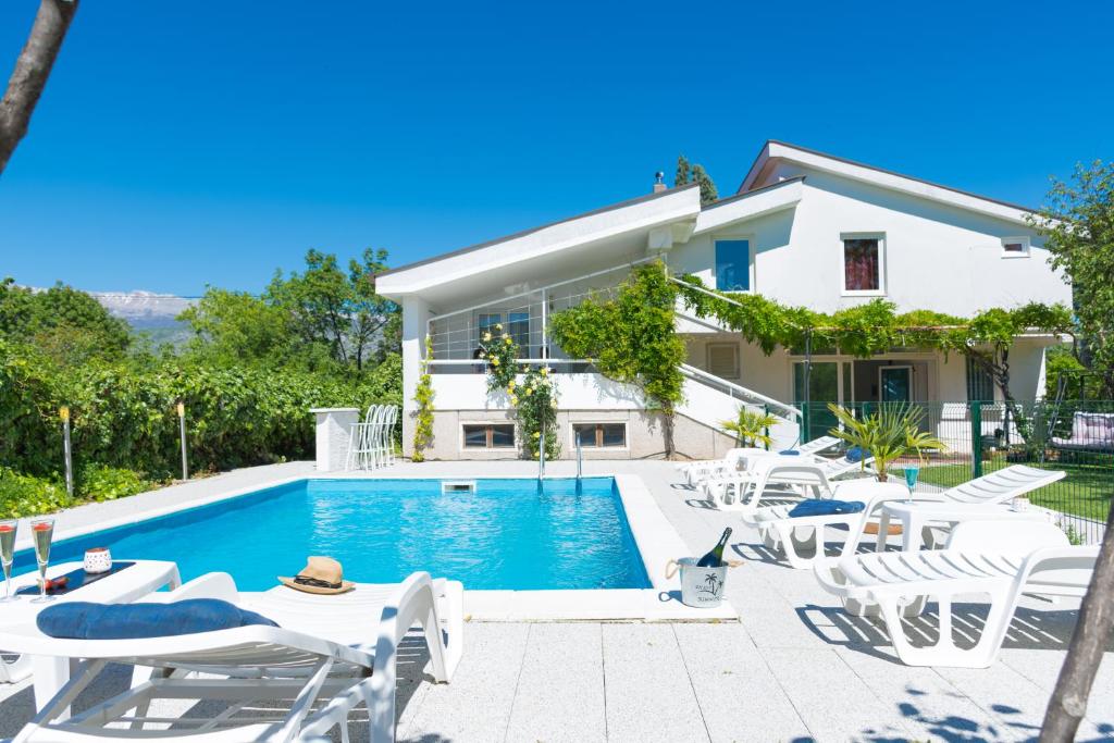 Villa con piscina y sillas blancas en Vacation Home Mirasole, en Mostar