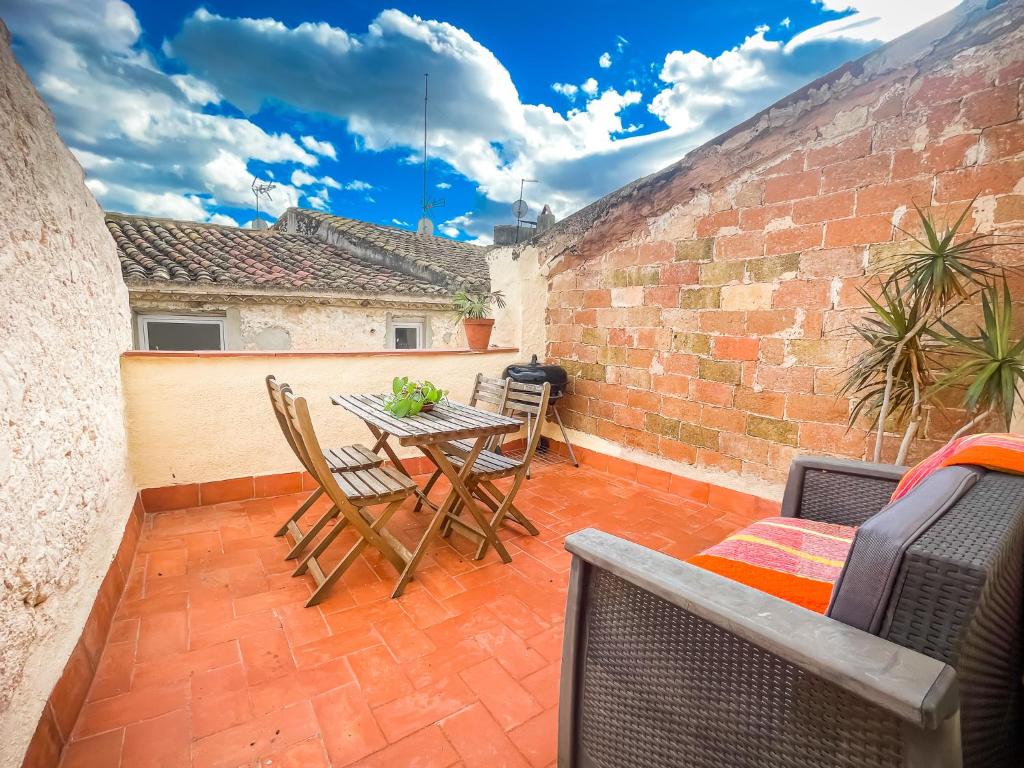 a patio with a table and chairs and a brick wall at Unik Vacation Ca La Lola in Nulles