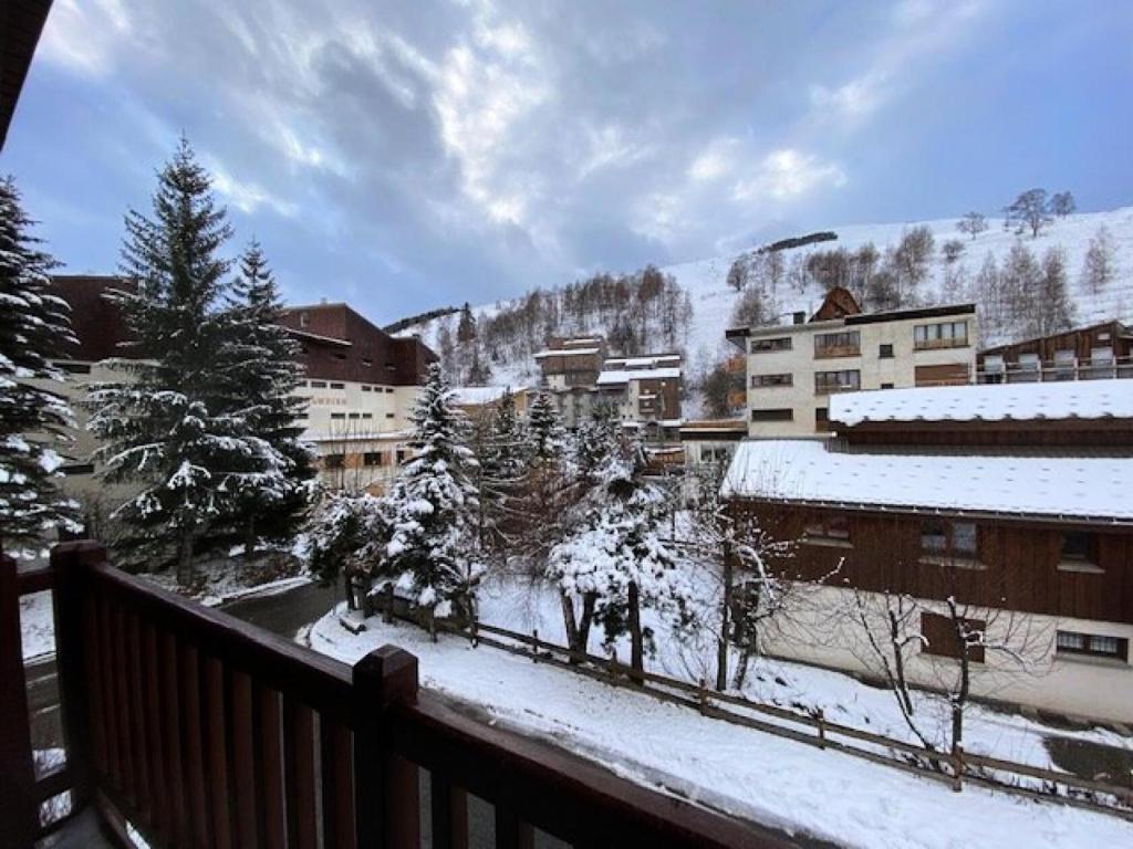 uma vista para uma cidade com edifícios cobertos de neve em Résidence Alpina Lodge - 3 Pièces pour 6 Personnes 184 em Vénosc