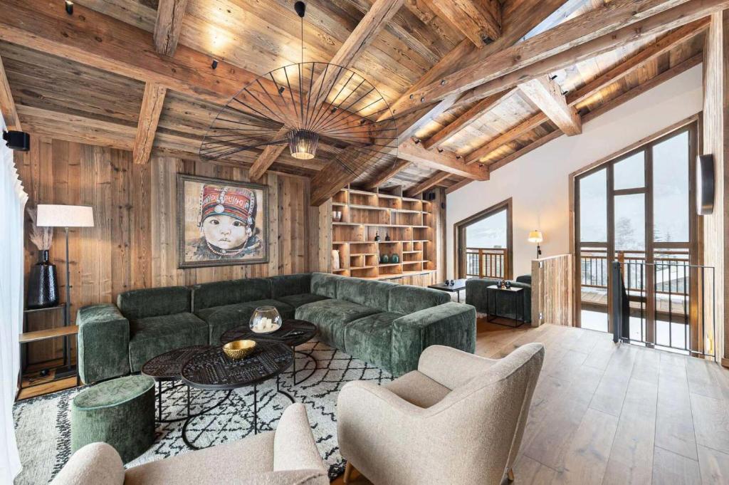 a living room with a green couch and chairs at Résidence Bois Du Ban - Chalets pour 10 Personnes 764 in le Praz