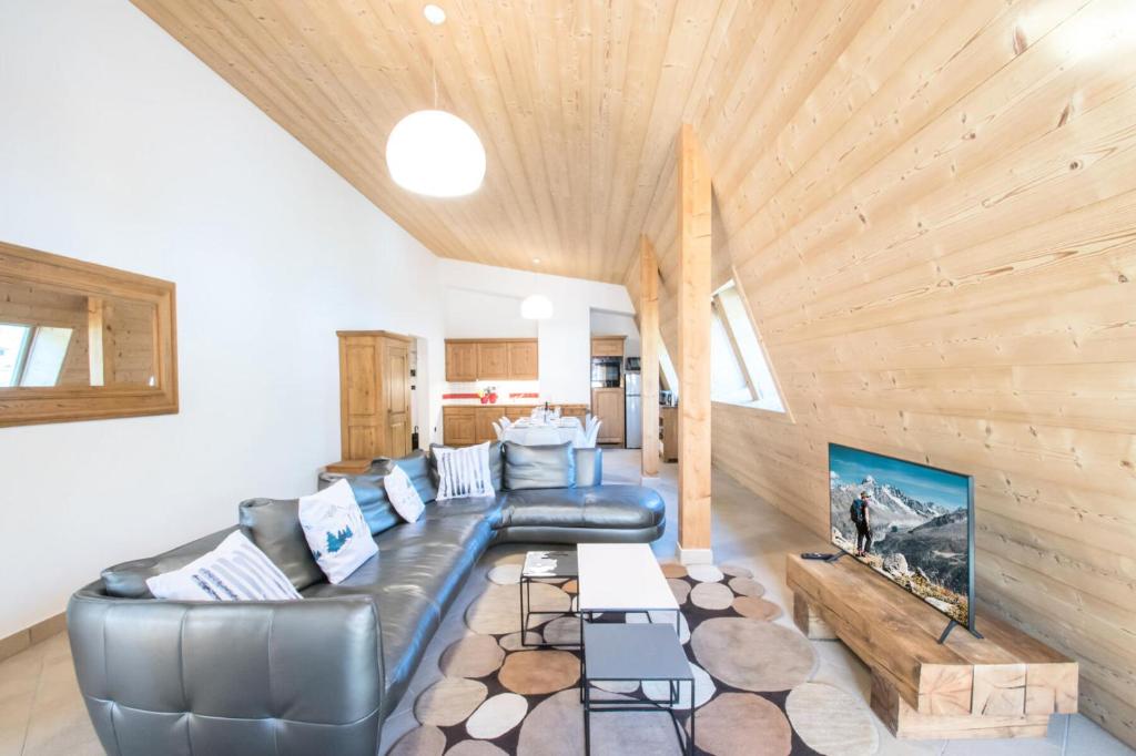 uma sala de estar com um sofá de couro e um tecto de madeira em Résidence Le Paradis - 5 Pièces pour 8 Personnes 774 em Chamonix-Mont-Blanc