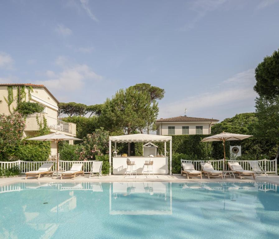 a swimming pool with chairs and a gazebo at Villa Roma Imperiale in Forte dei Marmi