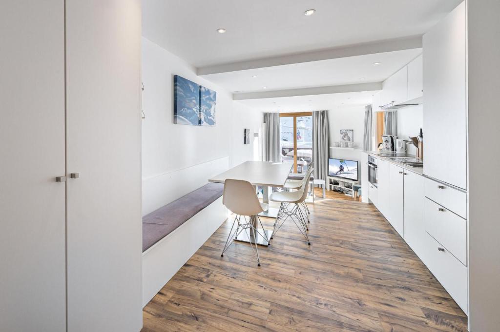 a kitchen and dining room with white cabinets and a table and chairs at Résidence Machu Pichu - 3 Pièces pour 6 Personnes 244 in Val Thorens