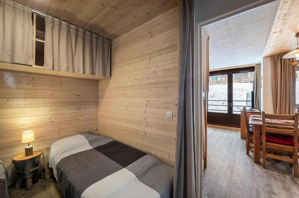 ein Schlafzimmer mit einem Bett in einem Zimmer mit einem Fenster in der Unterkunft Résidence Roc De Peclet 2 - Studio pour 4 Personnes 414 in Val Thorens
